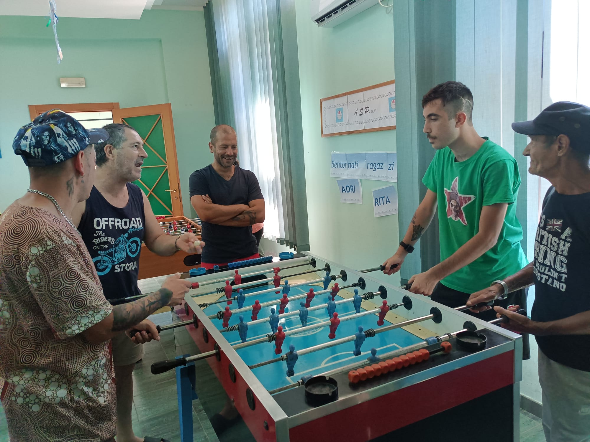 Partecipanti durante una partita di calcio balilla